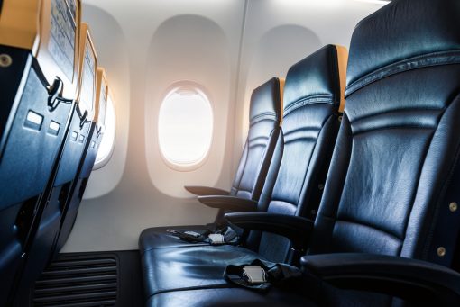 Plane interior - cabin with modern leather chair for passenger of airplane. Aircraft seats and window. - Horizontal image